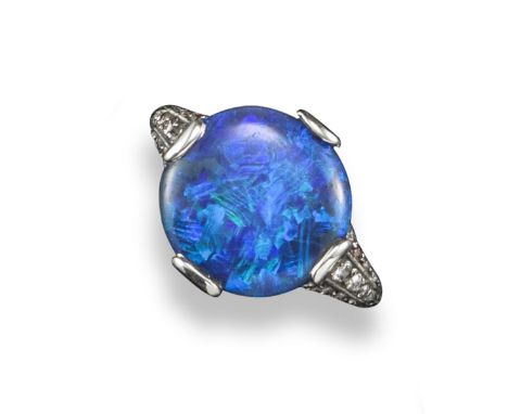 An opal and diamond cluster ring, the circular solid black opal, with old circular-cut diamonds set the the shoulders and gal