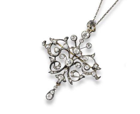 A late Victorian diamond brooch pendant, of scroll form and set with graduated cushion-shaped and circular-cut diamonds in si