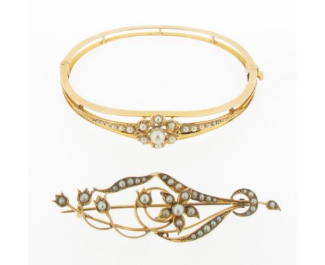 An Edwardian bangle, mounted with a line of graduated seed pearls centred with a central pearl within a seed pearl set openwo