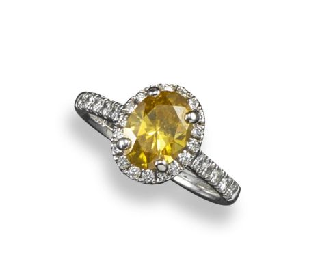 A yellow and white diamond solitaire ring, the oval-shaped yellow diamond is set within a surround of round brilliant-cut dia