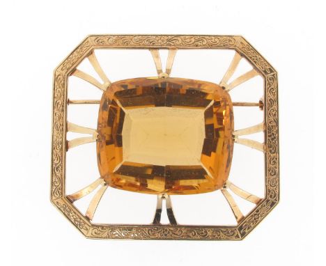 A large citrine brooch, the cushion-shaped citrine is set within carved and pierced octagonal gold mount. 4.4cm wide.