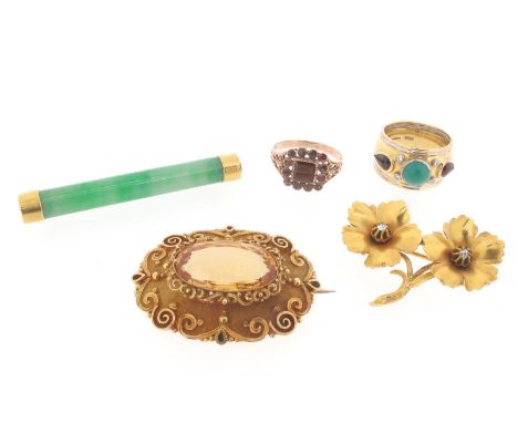 A citrine-mounted gold brooch, the oval-shaped citrine is set within a scrolling surround on a yellow gold brooch with furthe