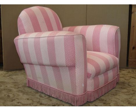 A vintage art deco style club armchair with repeating floral sprig and alternating light pink stripe upholstery with tassel a