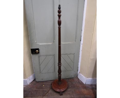 A lamp standard with turned and tapering column on a circular disc base with carved borders 