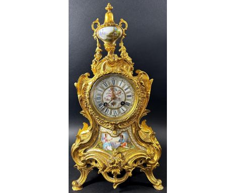 19th century French gilt brass mantle clock in a Rococo style with painted porcelain dial and lower panel, set beneath an urn