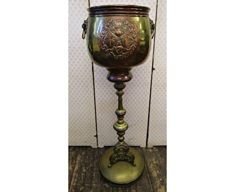 A late 19th century brass and overlaid copper jardinière and stand, the upper section with lion mask detail and ring handles,