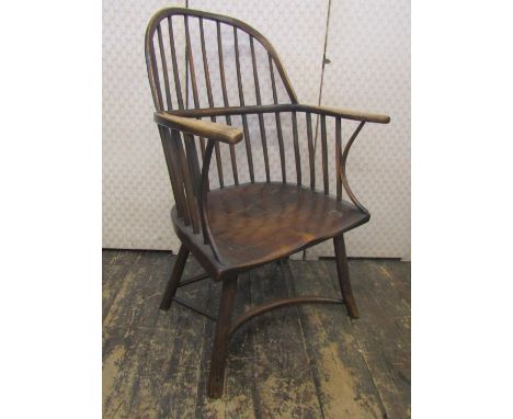An 18th century Windsor hoop back elbow chair, principally in ash, the simple stick supports united by a crinoline shaped str
