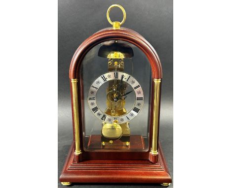 A contemporary skeleton clock, in an arched mahogany coloured and brass inlaid case 