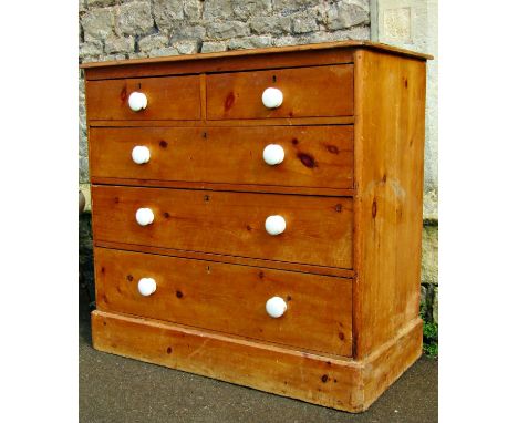 Victorian stripped pine bedroom chest of three long and two short graduated drawers, with ceramic handles and set on a plinth