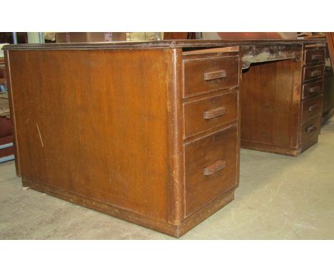 A large vintage kneehole twin pedestal office desk, one side fitted with eight drawers beneath brushing slides, the other cup