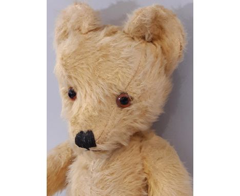 Vintage teddy bear, mid 20th century, with long golden plush, large ears, pronounced muzzle, glass eyes, stitched nose and mo