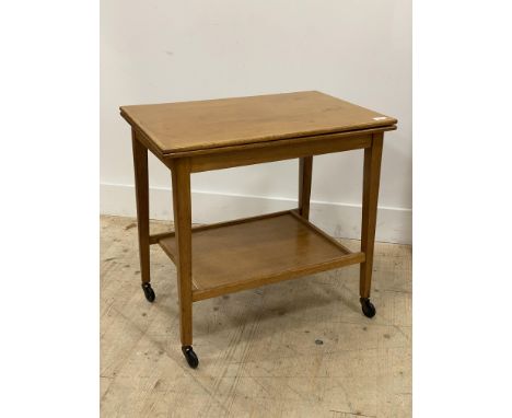 A mid century oak card table, having a fold over revolving top opening to a baize lined playing surface, above and under tier