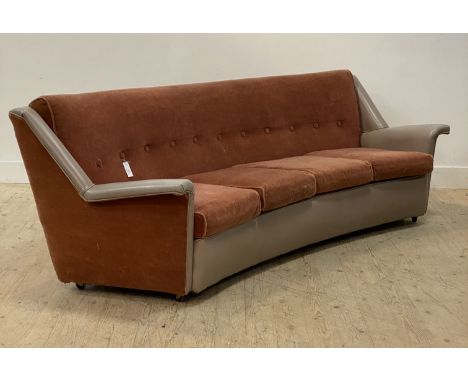 A mid century curvilinear four seat sofa, circa 1950's, upholstered in plush plum and vinyl and moving on castors. H80cm, L25