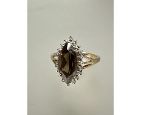 A 9ct gold dress ring set navette shaped cairngorm enclosed within a cz border S 3.57g