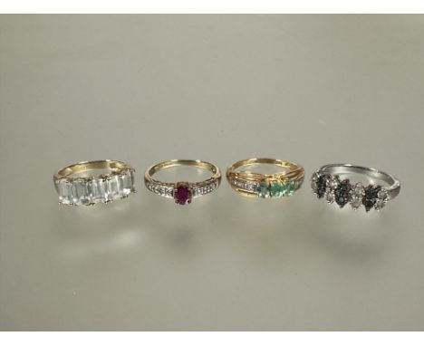 A group of four silver gem set rings to include a five stone cushion cut ring, a three stone green set ring, a green stone an