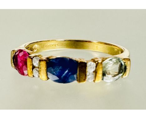 A 9ct gold three stone ring set central oval sapphire flanked by two diamond spacers and a oval aquamarine and ruby, stones s