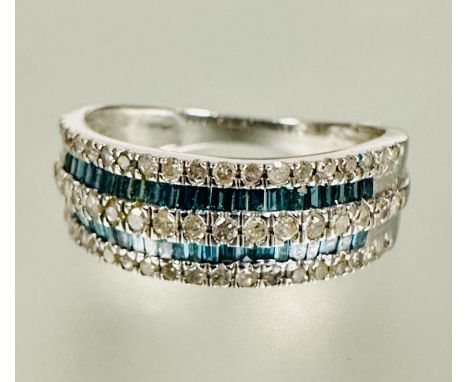 A 9ct white gold half eternity style ring twin channel set caliber green stones flanked enclosed within three rows of ninetee