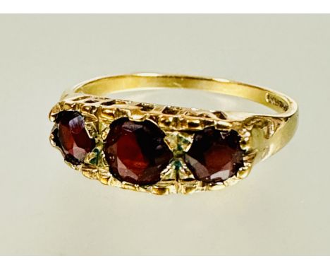 A 9ct gold graduated three stone circular garnet set ring center stone approximately 0.33ct N 2.06g