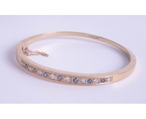 A 9ct sapphire and diamond set bangle, approx 14.20g.