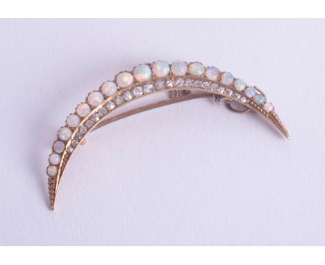 A antique opal and diamond set half crescent style brooch with safety chain, set with nineteen white opals of good colour and