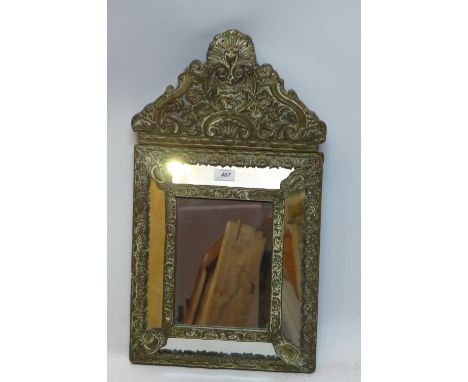 A 19th Century mirror with embossed brass mount, 62cm x 35cm