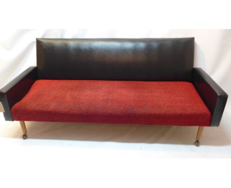 A mid 20th Century black leather sofa with fabric seat raised on tapered legs and castors