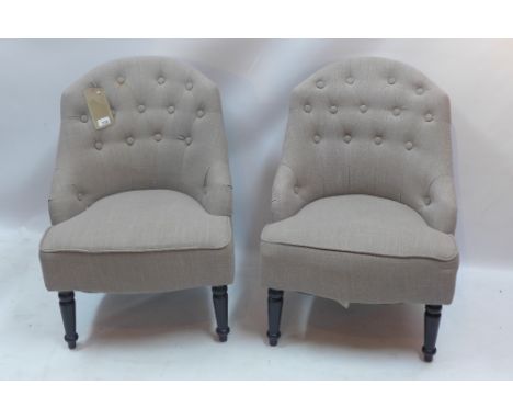 A pair of button back bedroom chairs with stone linen upholstery raised on turned legs