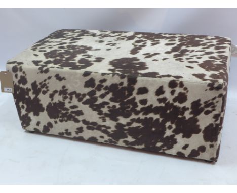 A contemporary pouffe with faux cow hide upholstery, H:40cm W:98cm D:51cm