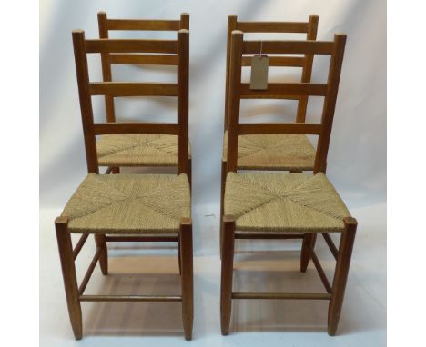 A set of four oak ladder back chairs with rush seats.