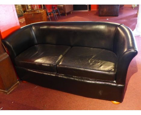 A contemporary black leather two seater sofa raised on bun feet, H:76cm W:150cm D:54cm