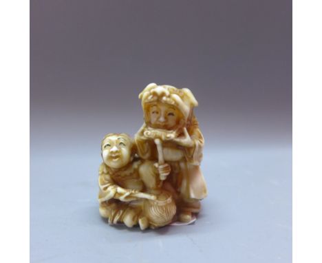 A Japanese Meiji ivory netsuke, modelled as figures with instruments, H.4cm