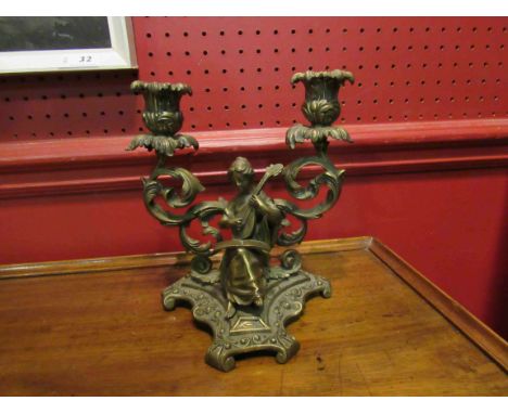A brass twin sconce candlestick with lady playing musical instrument, 20cm tall