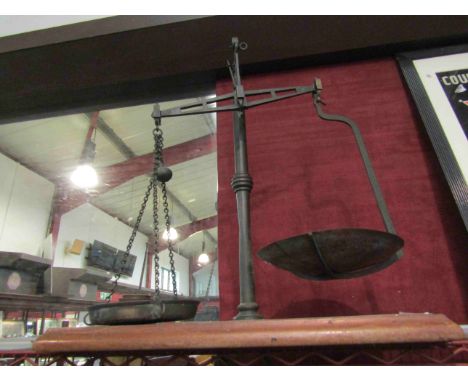 A set of weighing scales with weights, on wooden plinth