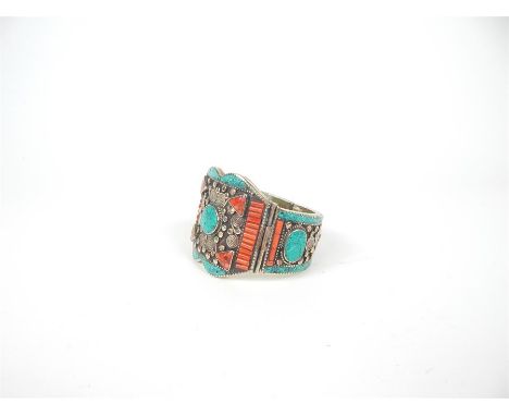A white metal probably alpacca bangle, set with turquoise and red agate, 6 x 8 x 7cm.