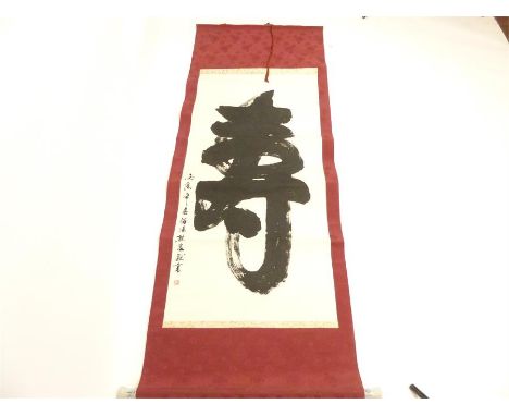 A Chinese calligraphy scroll with blue and white ceramic ends, 82cm wide.