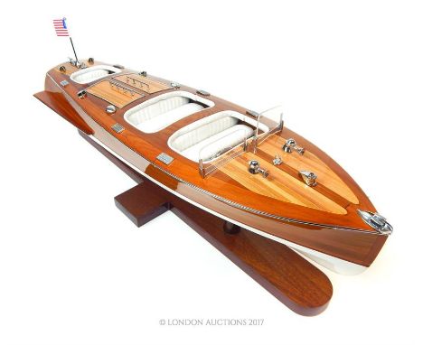 A model of a power boat with an American flag, raised on a stand, 19 x 60 x 17cm.