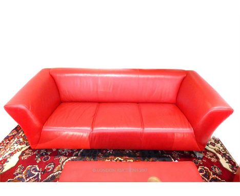 A contemporary red leather three seater sofa, raised on metal feet, 70 x 207 x 87cm.