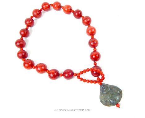 A necklace of red beads with jade style clasp in the form of the Buddha; 58cm long.