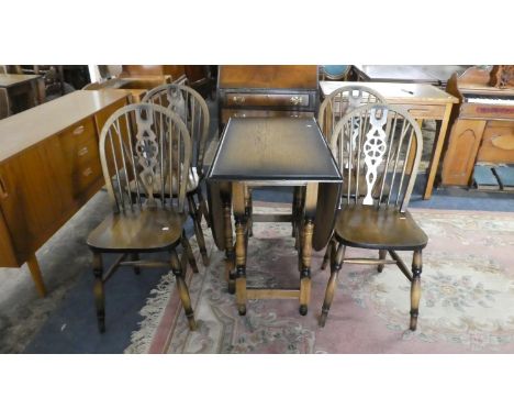 An Oak Drop Leaf Gate Leg Dining Table and Four Wheel Back Dining Chairs 