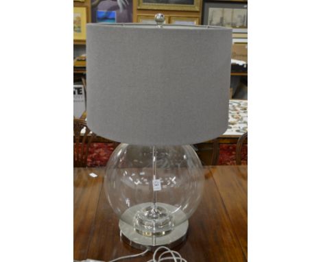 A large glass and chrome table lamp.