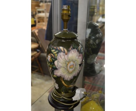A Moorcroft balister shaped table lamp on a wooden base.