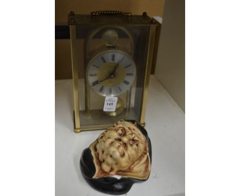A mantle clock and a pottery match holder.