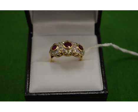 An 18ct gold ring with three clusters comprising rubies and diamonds size N.