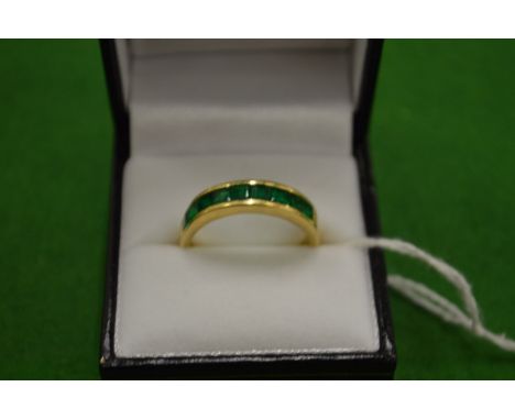 An 18ct gold ring set with 9 baguette cut treated emeralds size T.