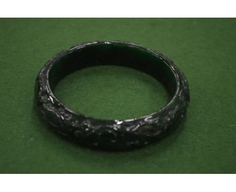 A Chinese carved green jade bangle.