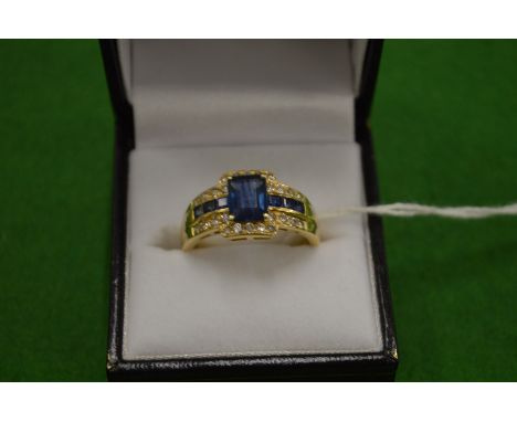 An 18ct gold diamond and synthetic sapphire ring size T.