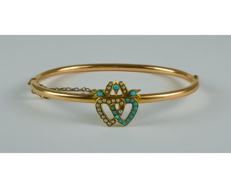 A 15ct Sweetheart Bangle, 20th Century, 185mm circumference, with two entwined hearts set with seed pearls and small turquois