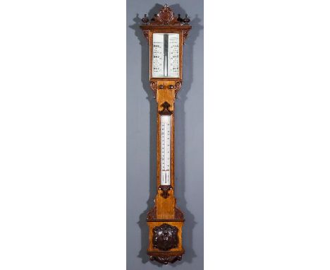 A Late Victorian Oak Cased Stick Barometer and Thermometer, with glass scale and twin vernier and mercury thermometer, contai