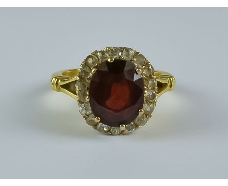  A Ruby and Diamond Ring, 20th Century,  18ct gold set with a centre ruby,  approximately 3ct, surrounded by eighteen small d