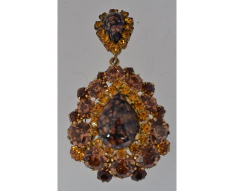 A vintage yellow metal drop pendant brooch with amber and brown paste stones with central glitter stone teardrops with a roll